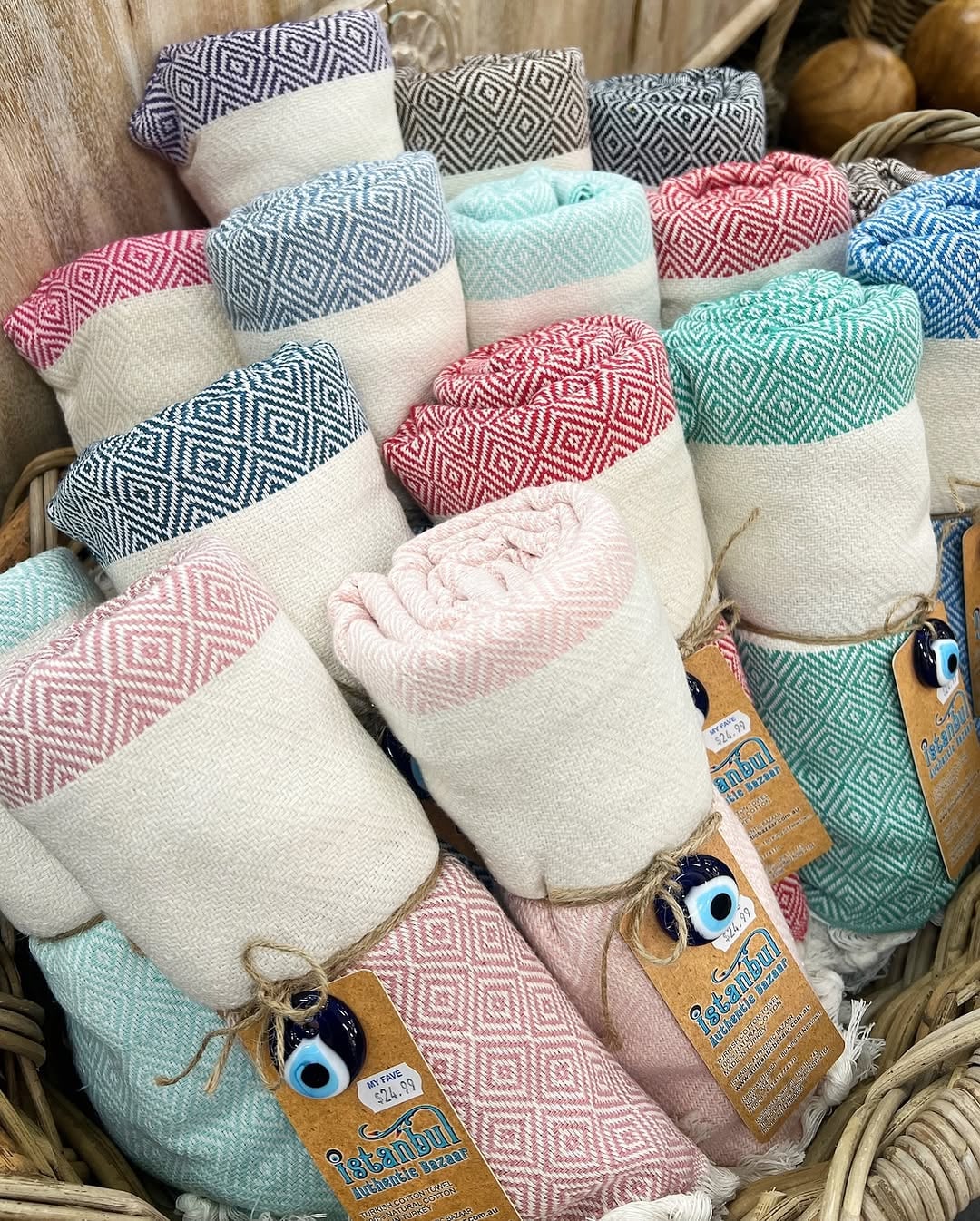 Folded stack of striped cotton peshtemal towels in muted pastel colors at a hammam shop
